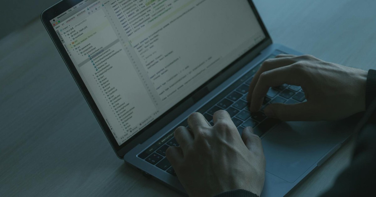 Hands typing code on a laptop keyboard