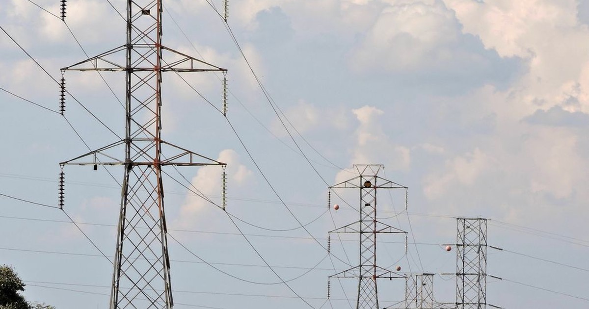 Electricity transmission tower against a dark sky